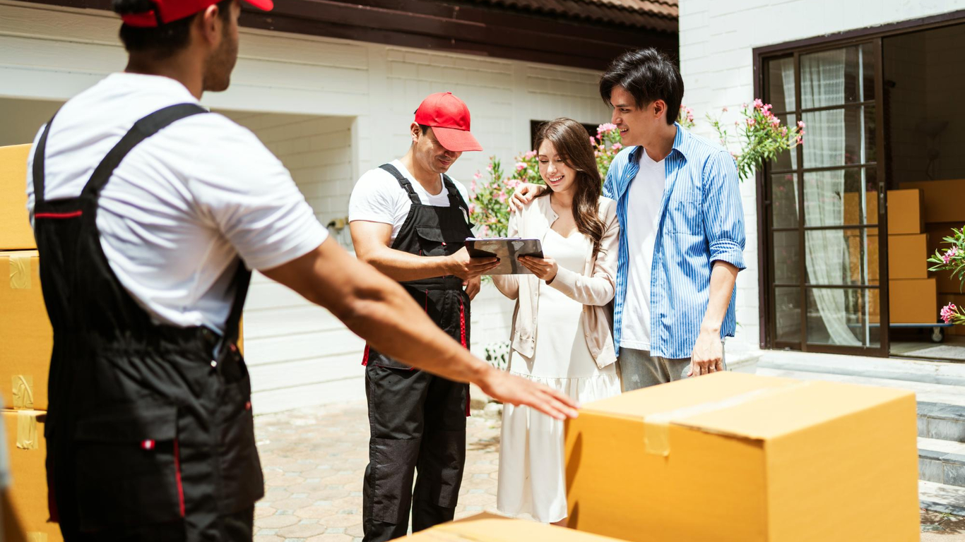 Moving team reviewing delivery checklist with customers outside home – Easy Best Moves