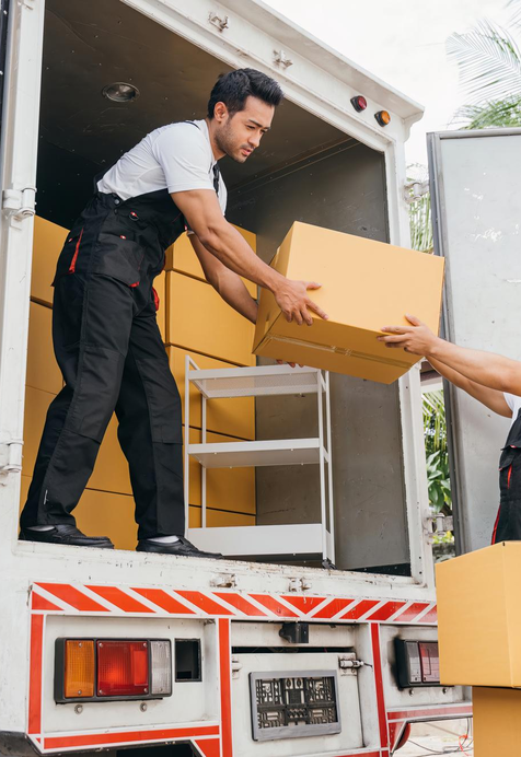 Mover handing packed boxes from truck during professional relocation – Easy Best Moves